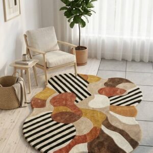 Abstract irregular shaped area rug featuring bold black and white stripes and organic geometric shapes in terracotta, mustard, beige, and brown.